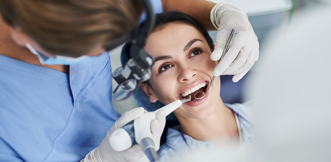 Charming young woman receiving dental treatment at clinic