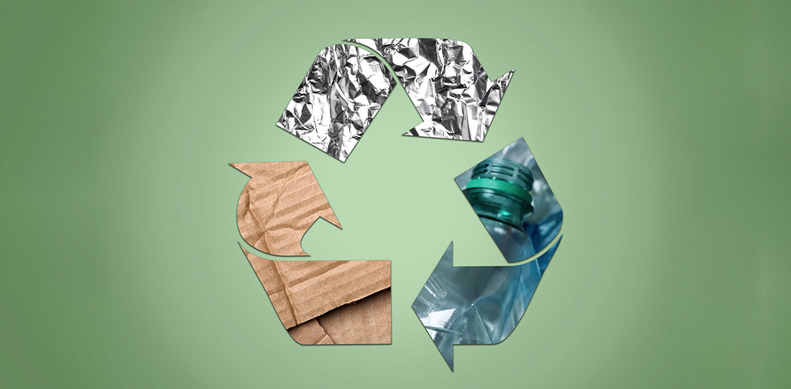 Recycling symbol made of crumpled foil, plastic bottles and card