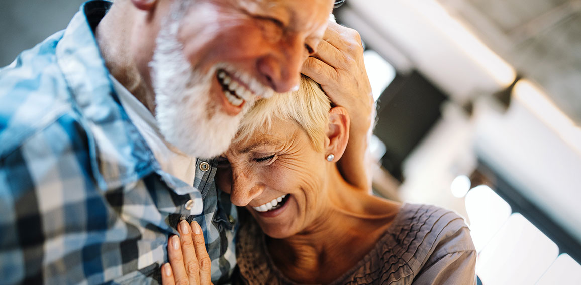 Happy senior couple in love hugging and bonding with true emotions at home