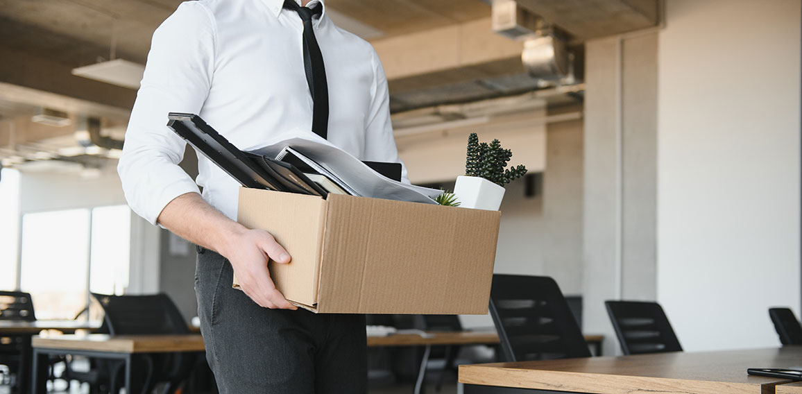 Economist leaving office. Handsome economist leaving the office taking his box with different things