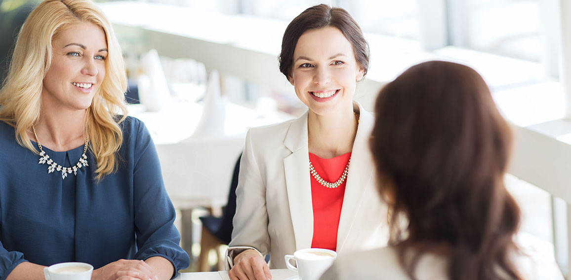 women drinking coffee and talking at restaurant