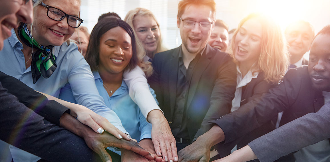 United coworkers standing with their hands together in modern of