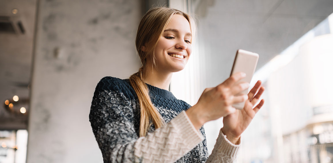 Junge-Frau-Smartphone-Laecheln-215720180-DP-Oleksii-Didok