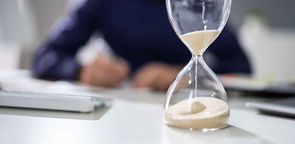 Businessperson's Hand Calculating Invoice In Office