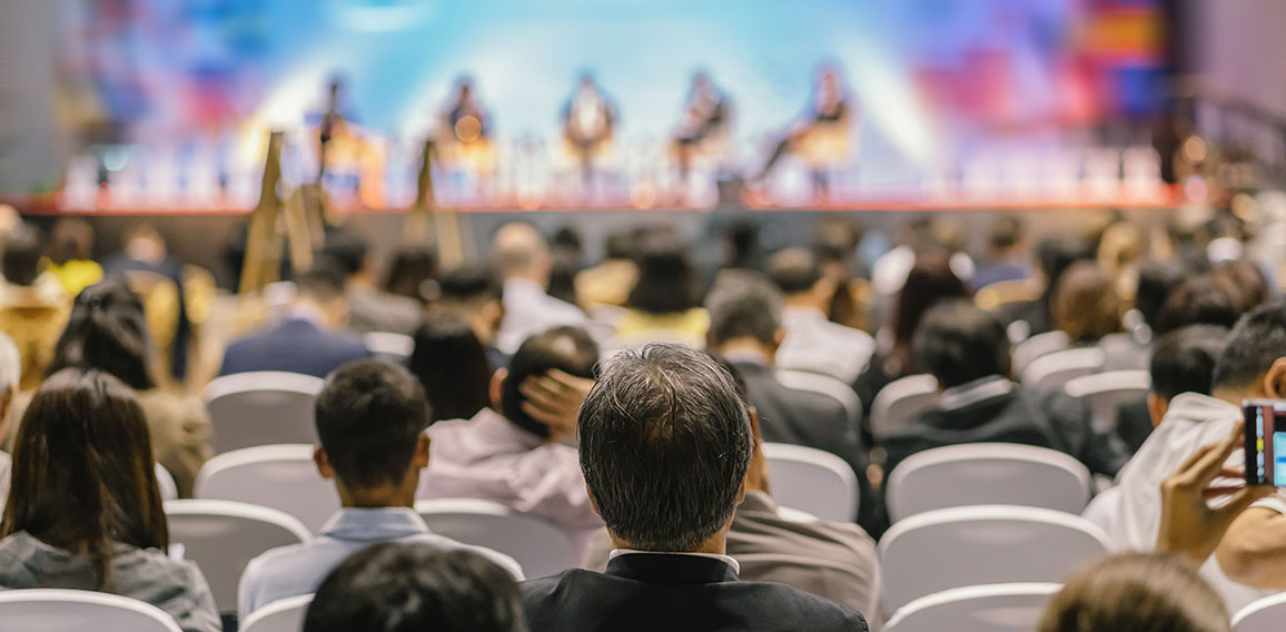 Rear view of Audience listening Speakers on the stage in the con