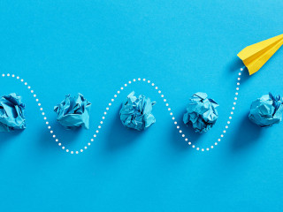 Paper plane passes through the crumpled paper balls.