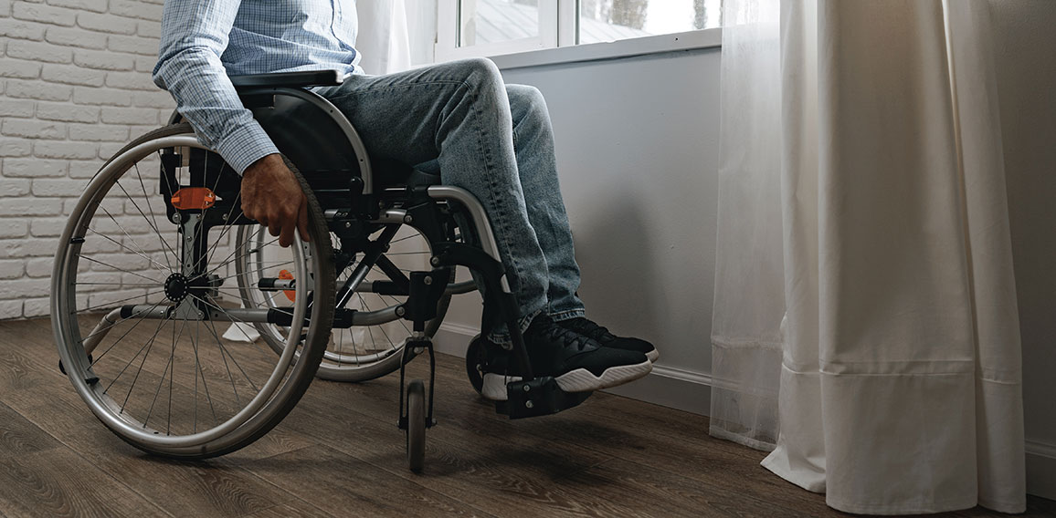 Disabled man sitting in a wheelchair and wearing face mask