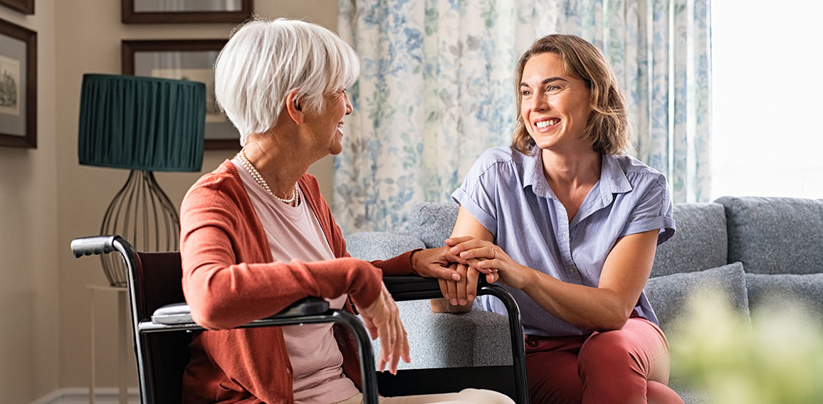 Happy adult woman visiting her elderly mother at home