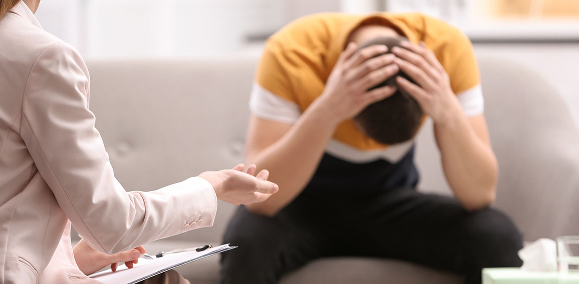 Psychotherapist working with young man in office