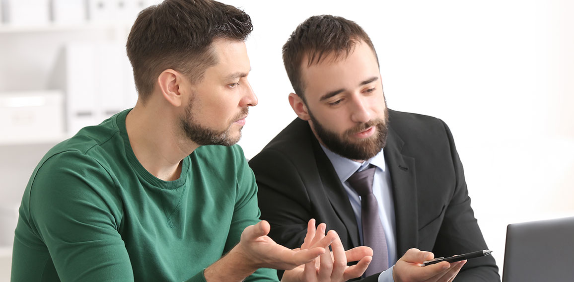 Businessman consulting young man in office