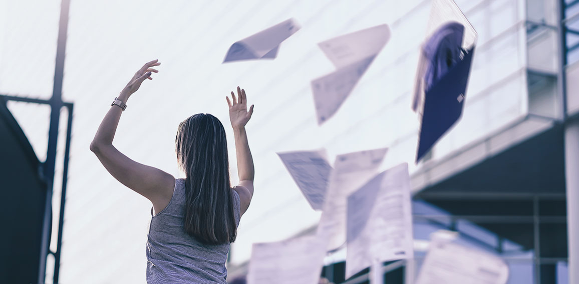 Business woman throwing work papers in the air. Stress from work