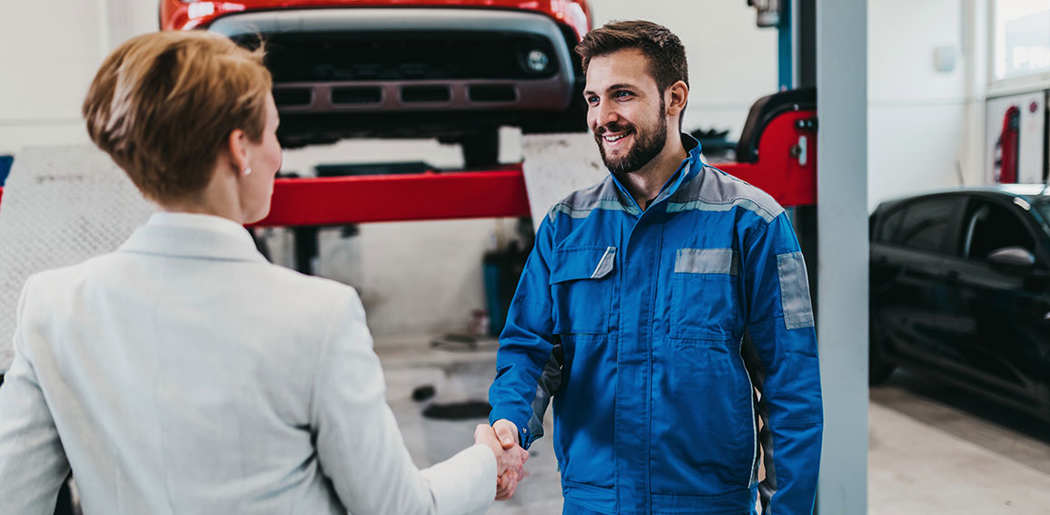 A middle-aged businesswoman in a modern and clean car repair sho