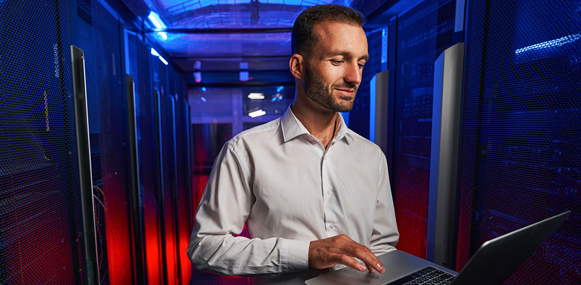 Bearded confident maintenance engineer in white shirt is working in database center