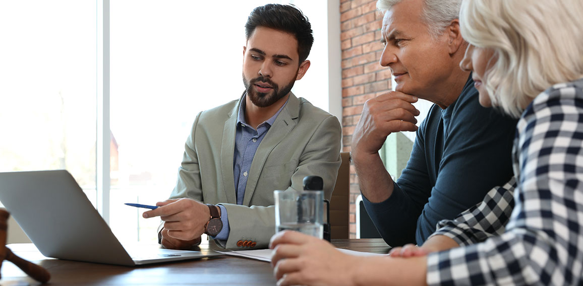 Male notary working with mature couple in office