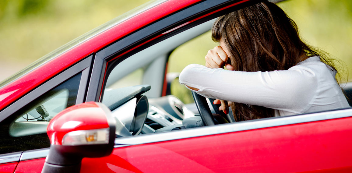 Young woman sitting depressed in car