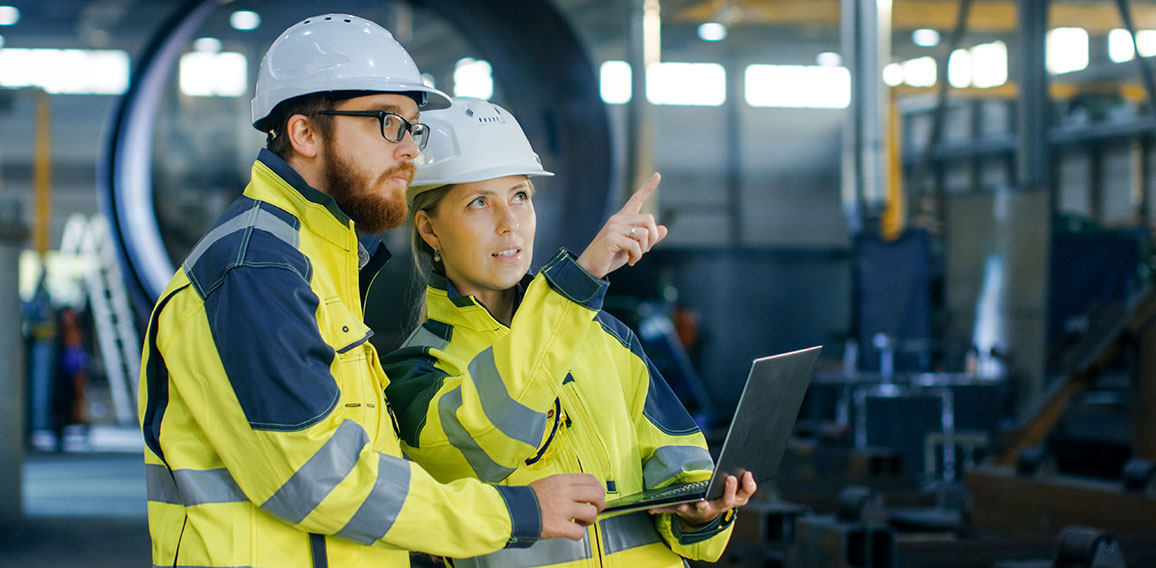 Portrait of Male and Female Industrial Engineers in Hard Hats Di