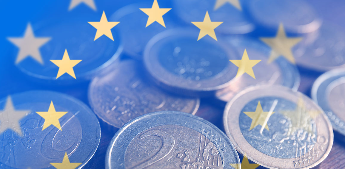 Many Euro coins on wooden table, closeup