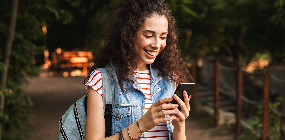 Photo of young delighted woman 18-20 with backpack, smiling and