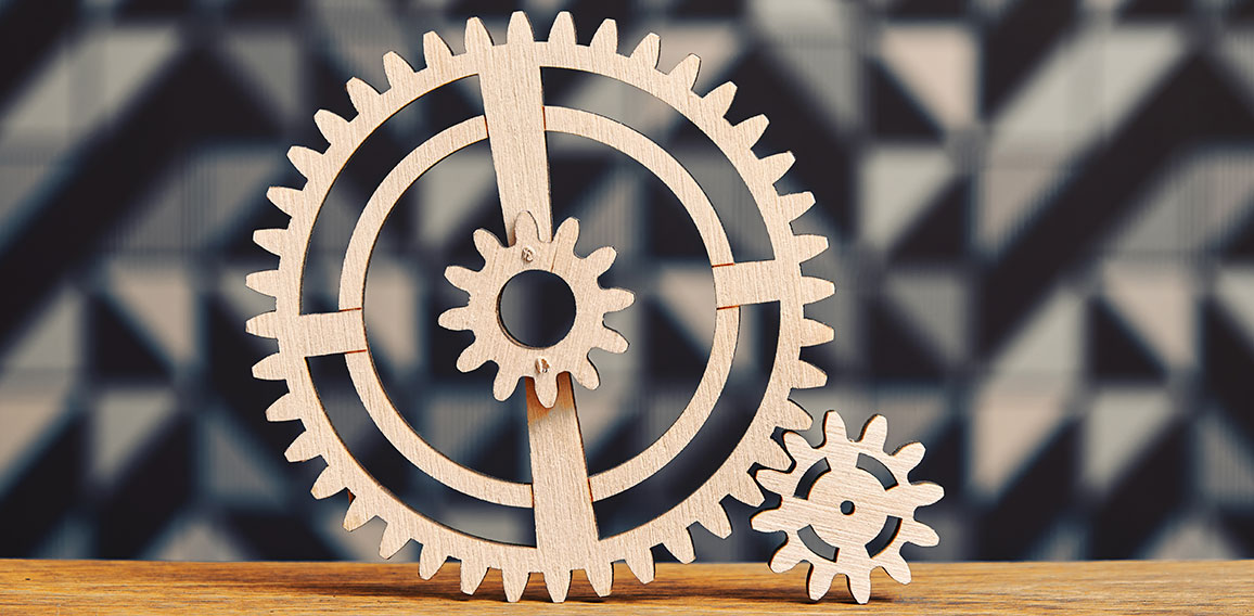 System of a wooden cogwheels on the wide wooden table