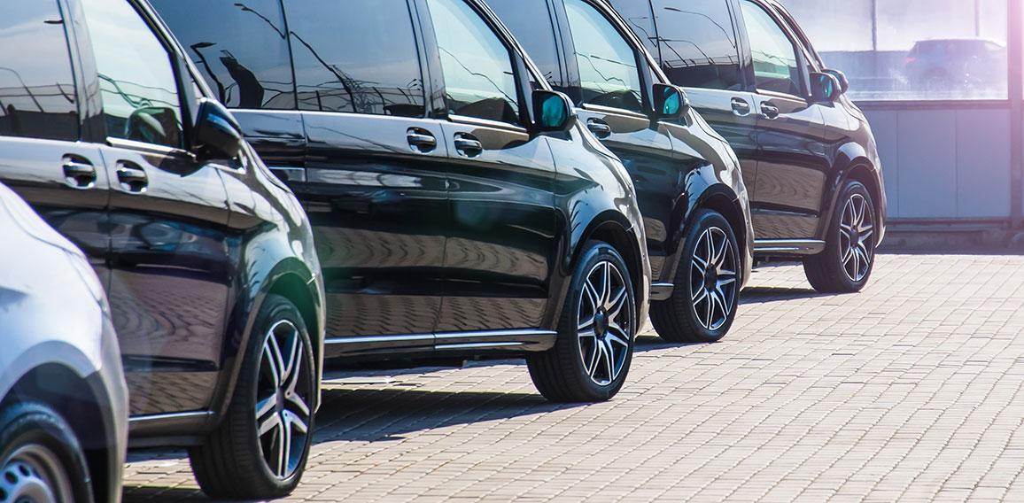 Dark colored passenger vans in a parking lot.