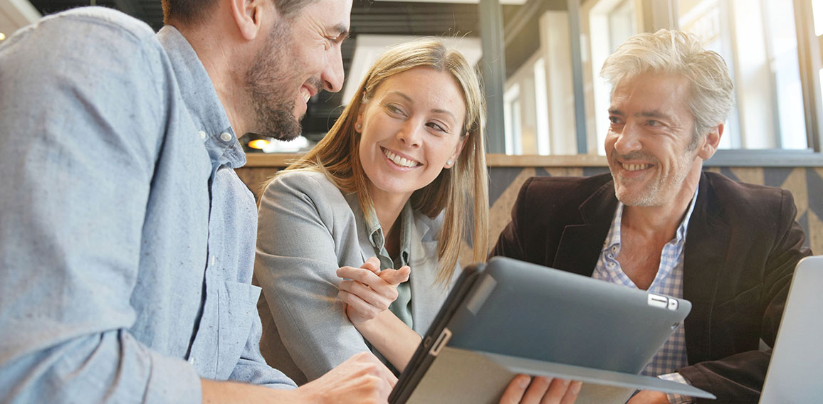 Smiling sales team working through presentation with manager