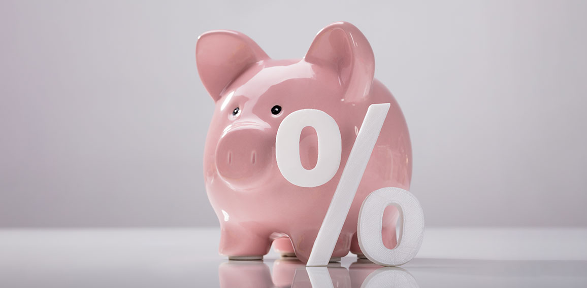 Close-up Of Percentage Sign And Piggy Bank