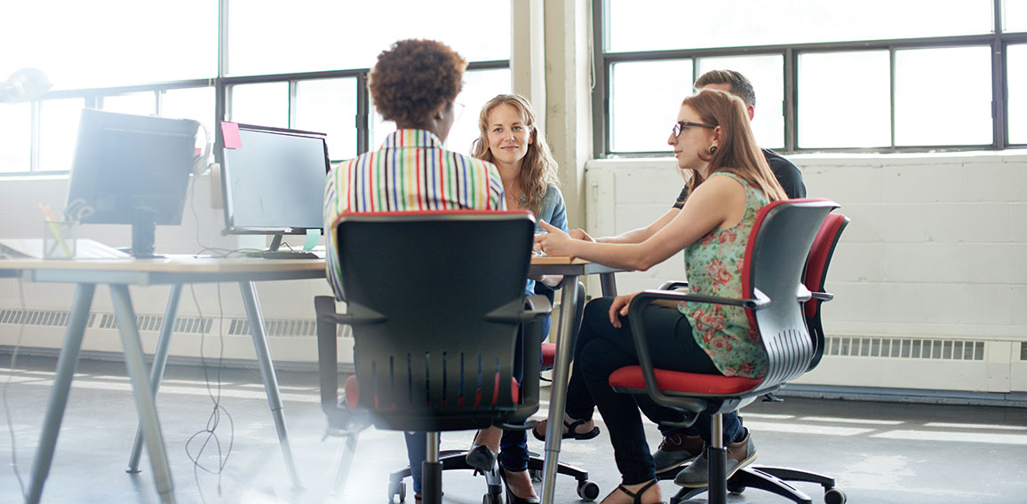 Unposed group of creative business people in an open concept office brainstorming their next project.