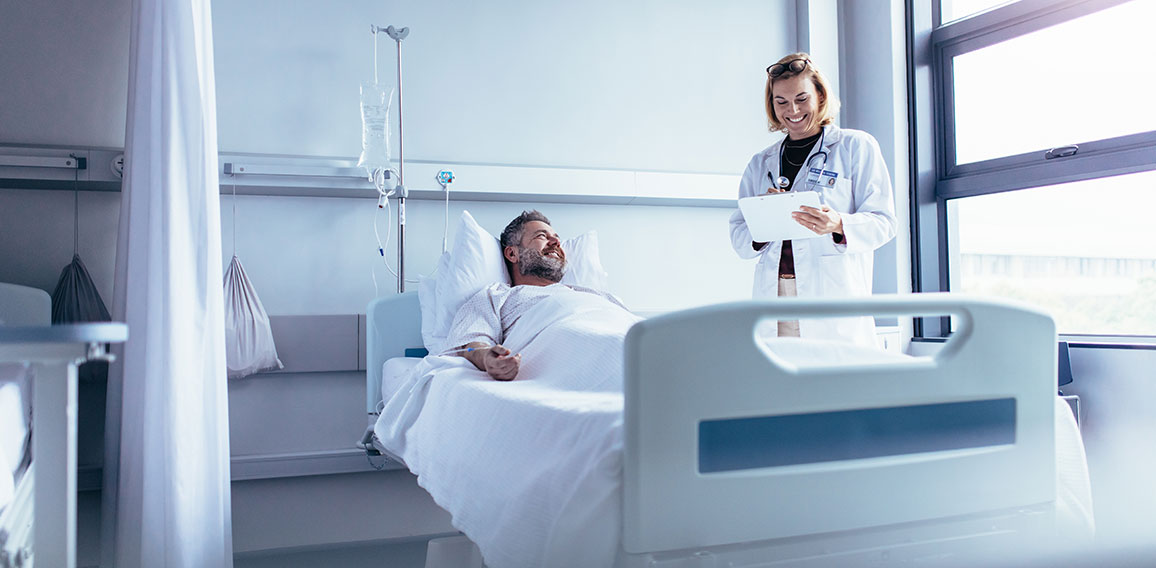 Doctor attending sick patient in hospital bed