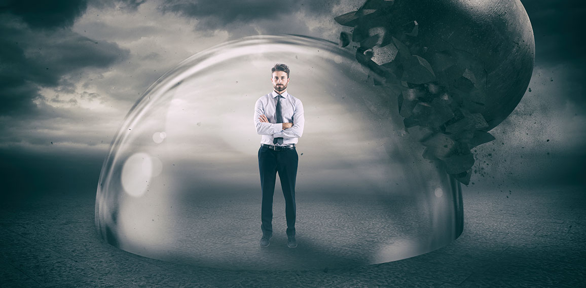 Businessman safely inside a shield dome during a storm that protects him from a wrecking ball. Protection and safety concept