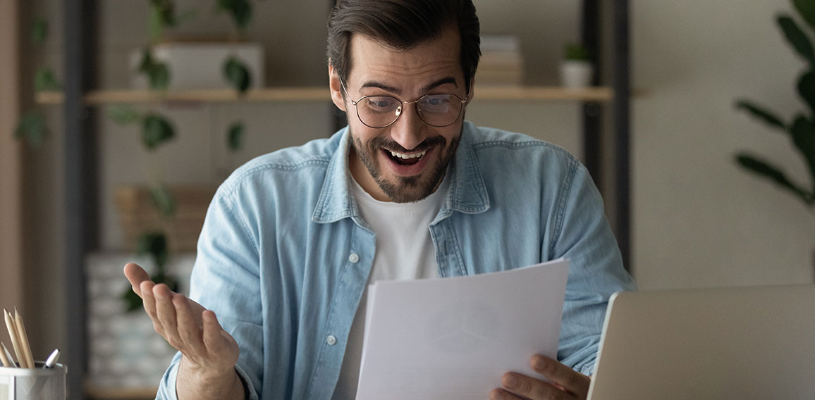 Surprised guy reading exciting news feels happy