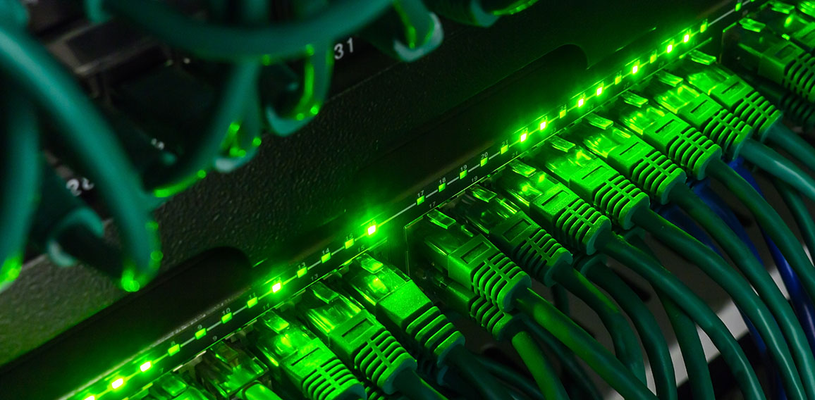 Close up of green network cables connected to switch glowing in the dark