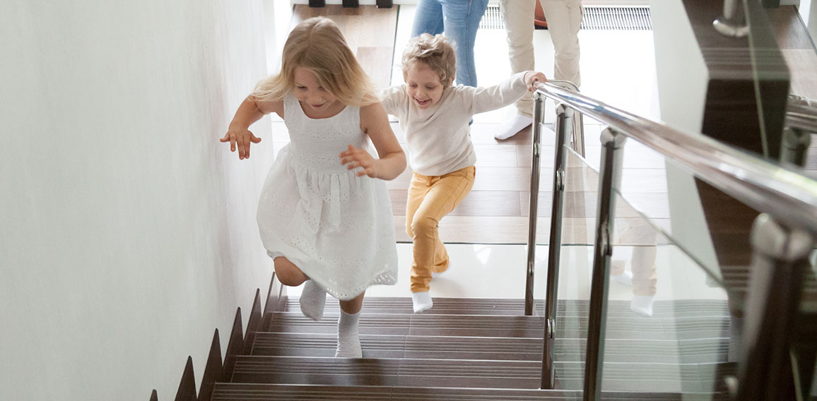 Children going upstairs to second floor their new modern house