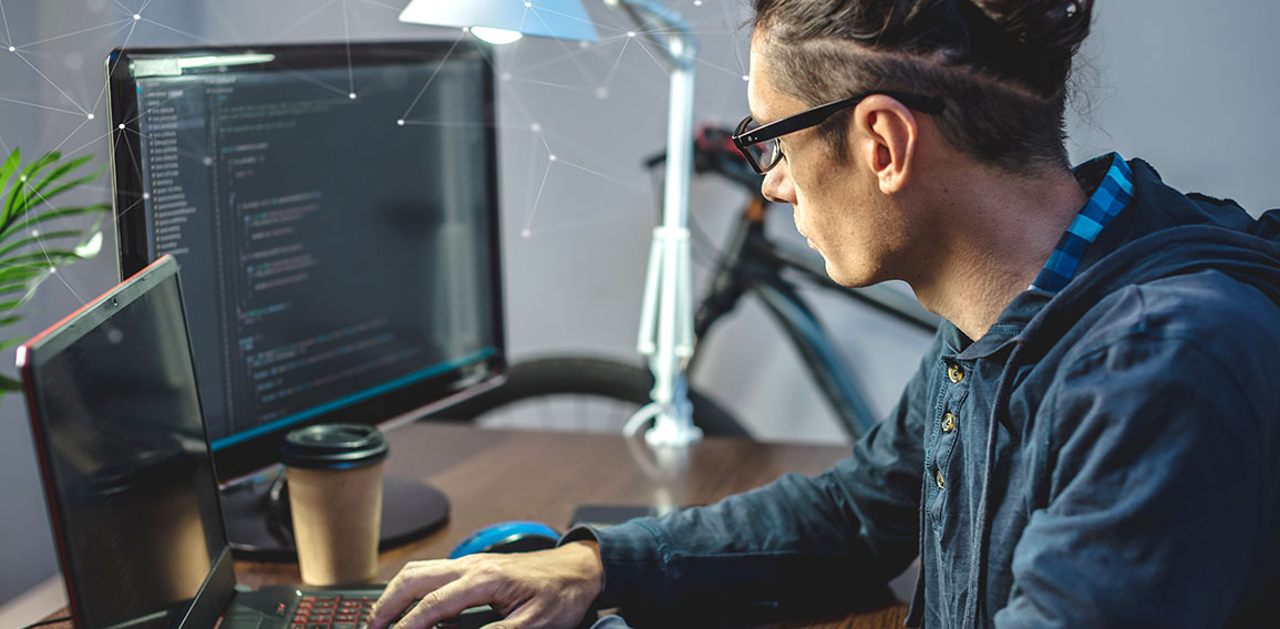 Male programmer is writing program code on a laptop at home. The concept of software development