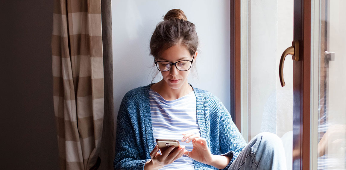 Young woman working from home office. Freelancer using laptop, phone and the Internet.