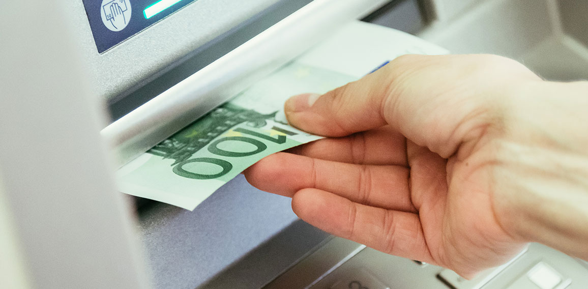 Close op of young woman withdrawing money from an atm