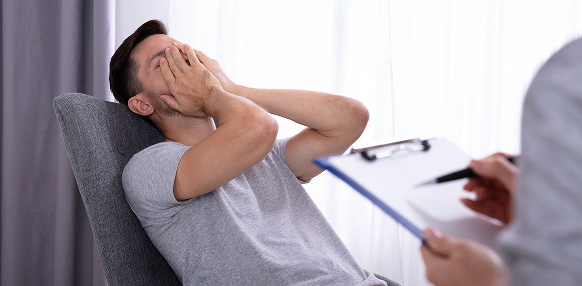 Psychologist Sitting Near Man Suffering From Depression