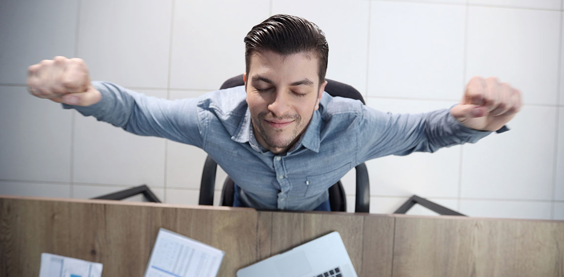 A male office worker is tired and warming up