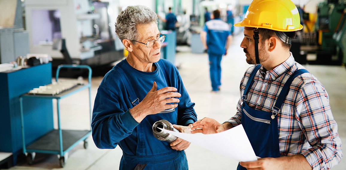 Factory worker discussing data with supervisor in metal factory