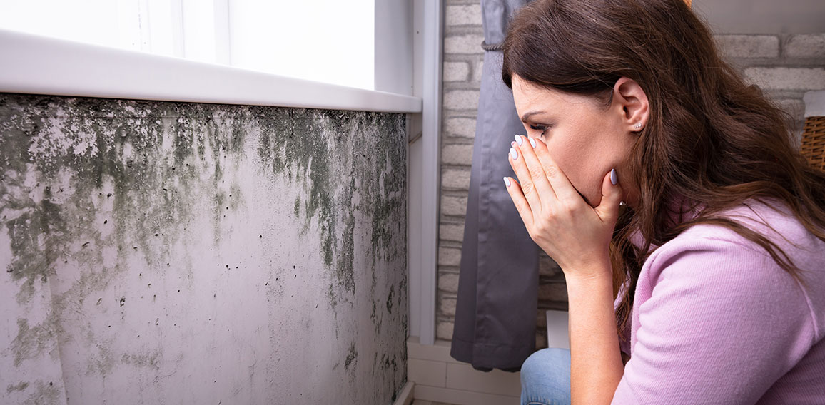 Shocked Woman Looking At Mold On Wall