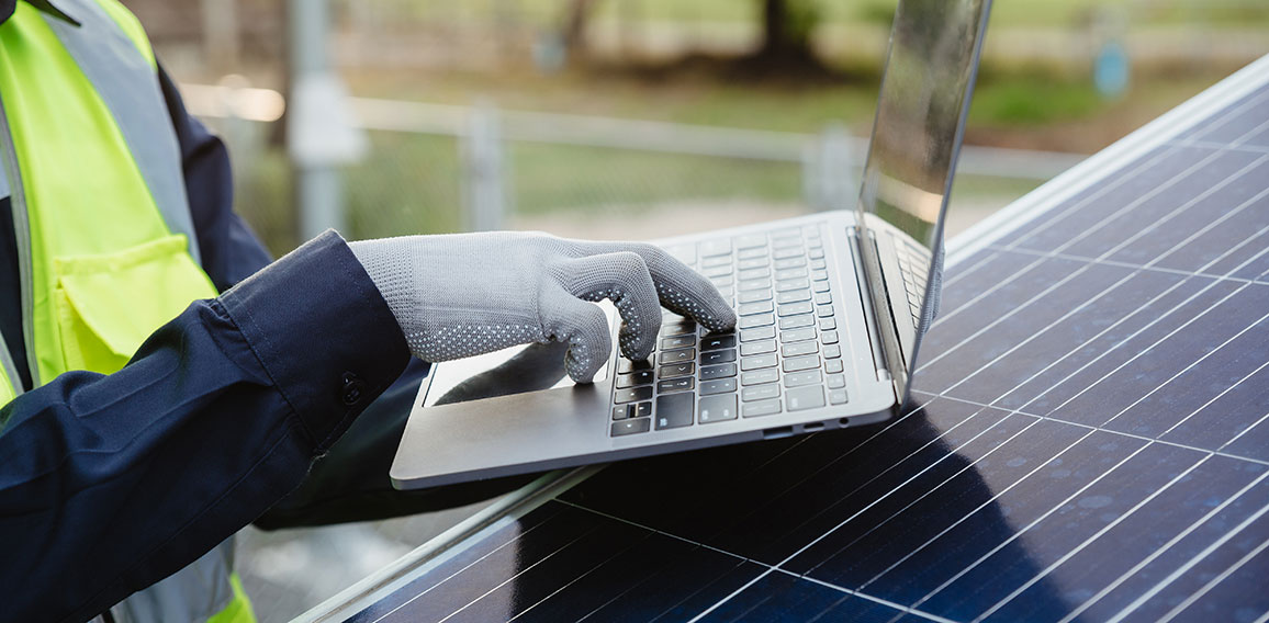 Engineer man working with laptop in solar panels.