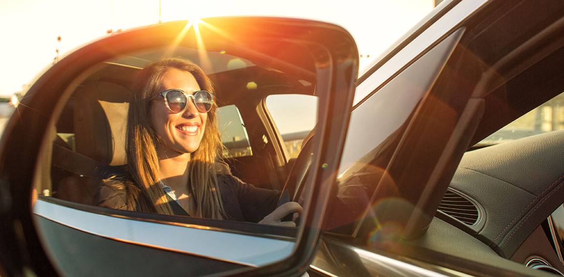 Beautiful businesswoman in rear view mirror with sunglasses