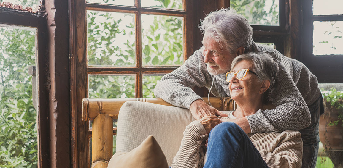 Old caucasian couple spending leisure time looking out through w