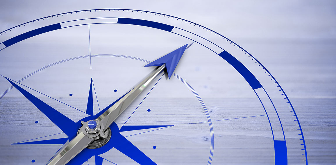 Compass against bleached wooden planks background