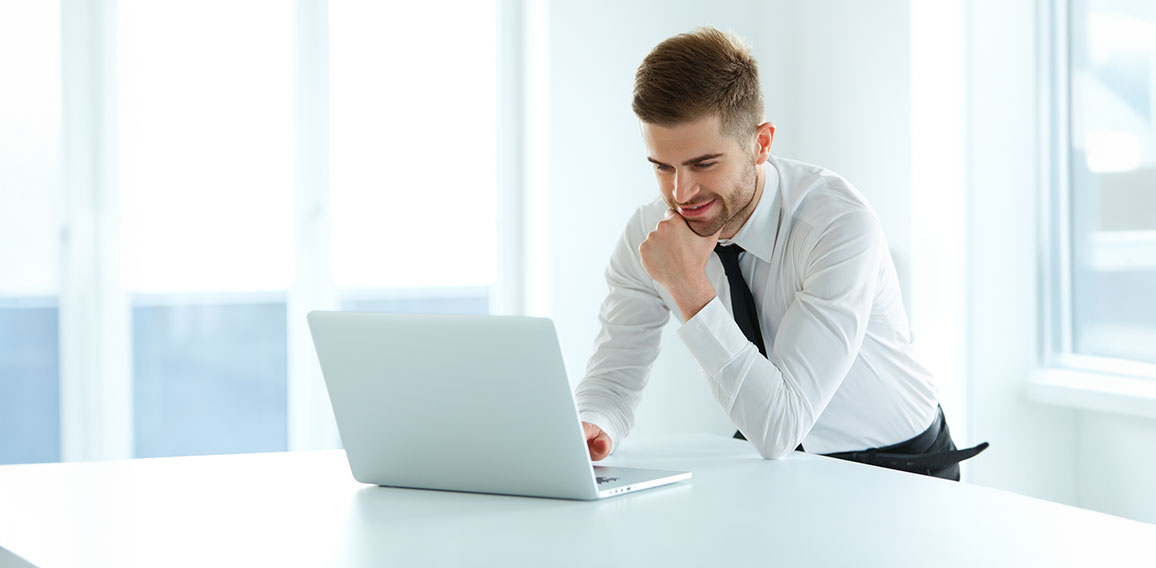 Handsome Businessman Working on Laptop at His Office