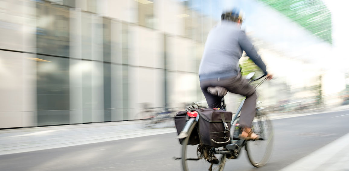 Mann fährt mit einem Pedelec im Straßenverkehr, Bewegungsunsch