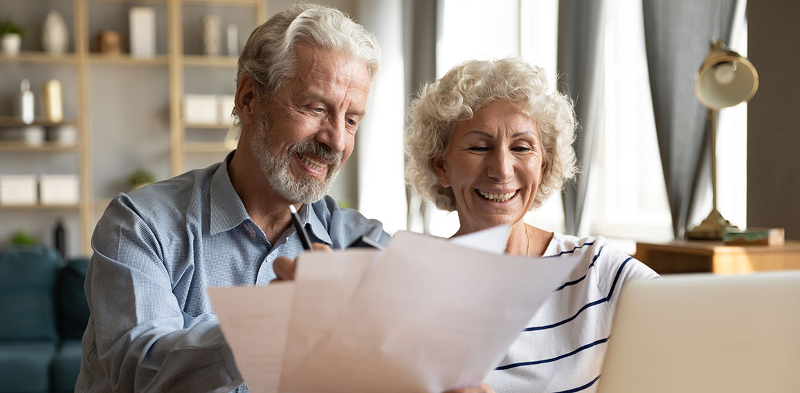 Senior couple use online banking on laptop planning family budget