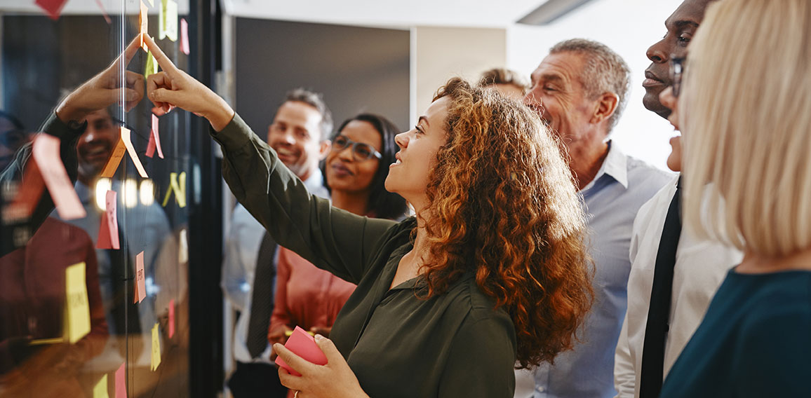 Diverse businesspeople brainstorming with sticky notes in an off