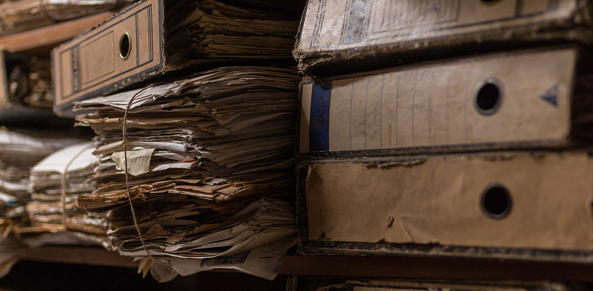 Old dusty stack of papers, files, documents on the shelves of ar