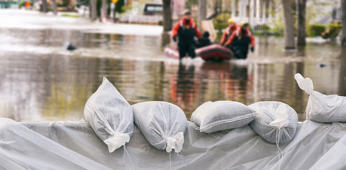 Flood Protection Sandbags with flooded homes in the background (