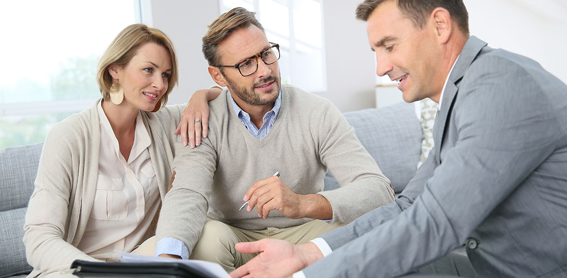 Couple with realtor signing mortgage contract